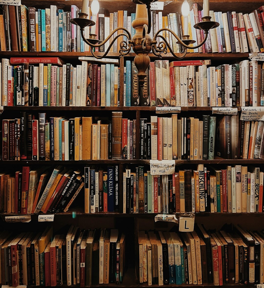 Tall wooden shelves filled with old hardcover books in a quiet library